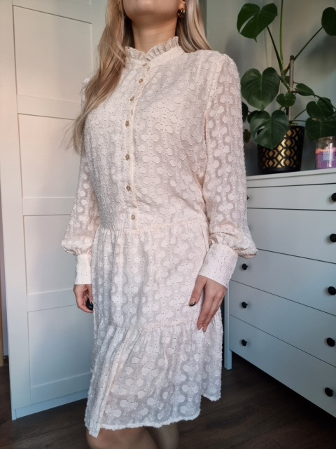 Kobieca, elegancka sukienka plumeti w śmietankowym kolorzez falbaną Kobieca, elegancka sukienka plumeti w śmietankowym kolorzez falbaną
