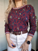 Burgundy blouse with an animal pattern and a cuff.